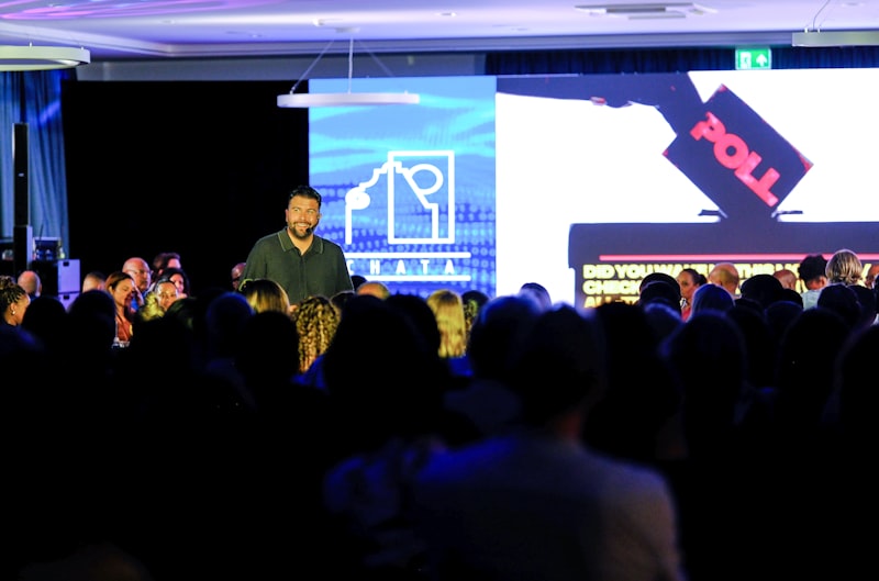 Speaker presenting at a professional seminar with audience watching